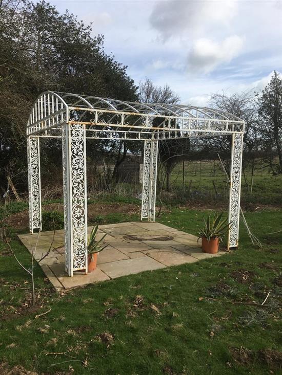 A large white painted wrought iron gazebo